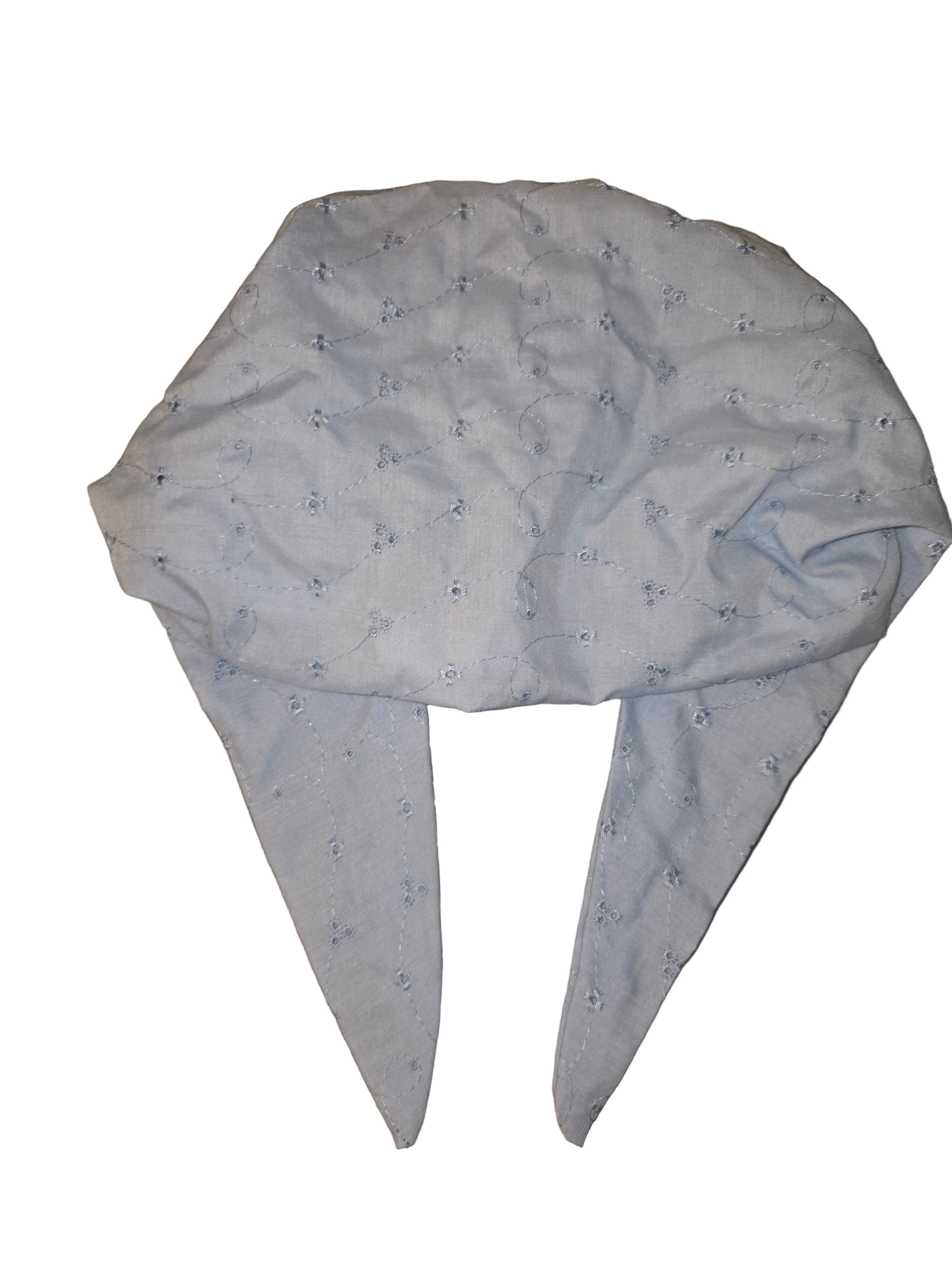 Baby shower cap with blue design on a reflective surface