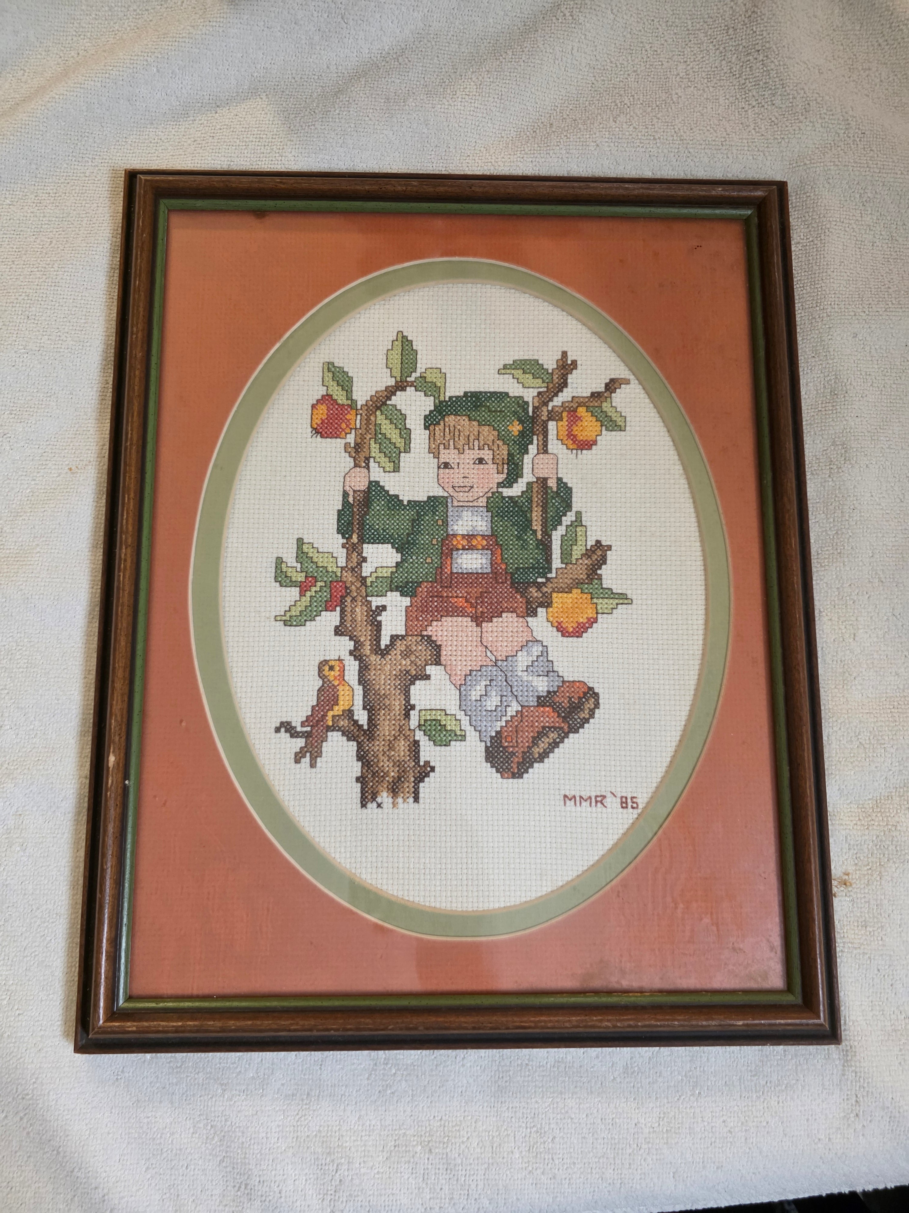 Framed cross-stitched picture of a boy on a branch with apples on a light backgroundtoaashop.com,toaa,thriftonline, thrift online, second hand, used stuff,