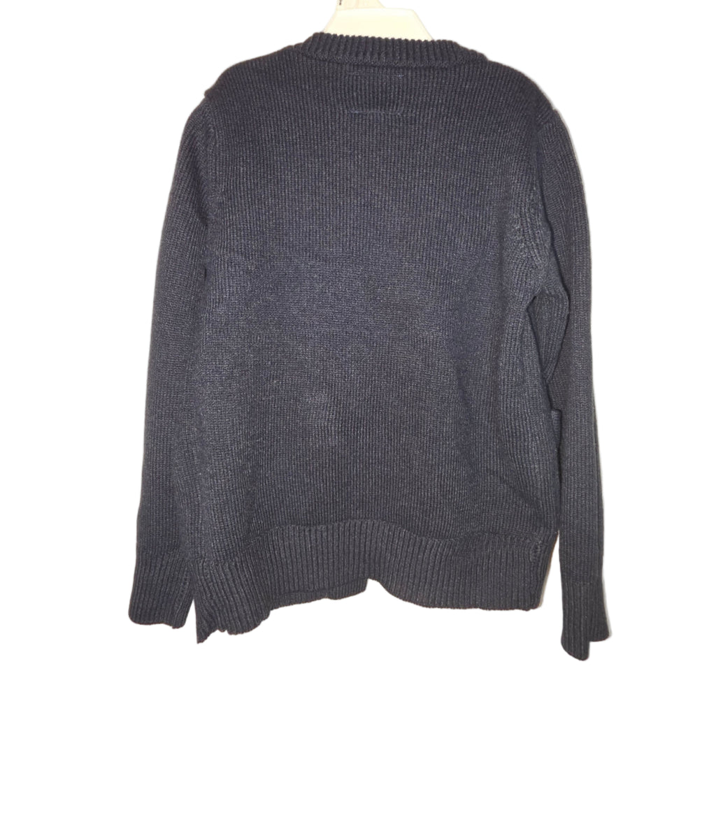 Folded dark gray sweater on a light beige background