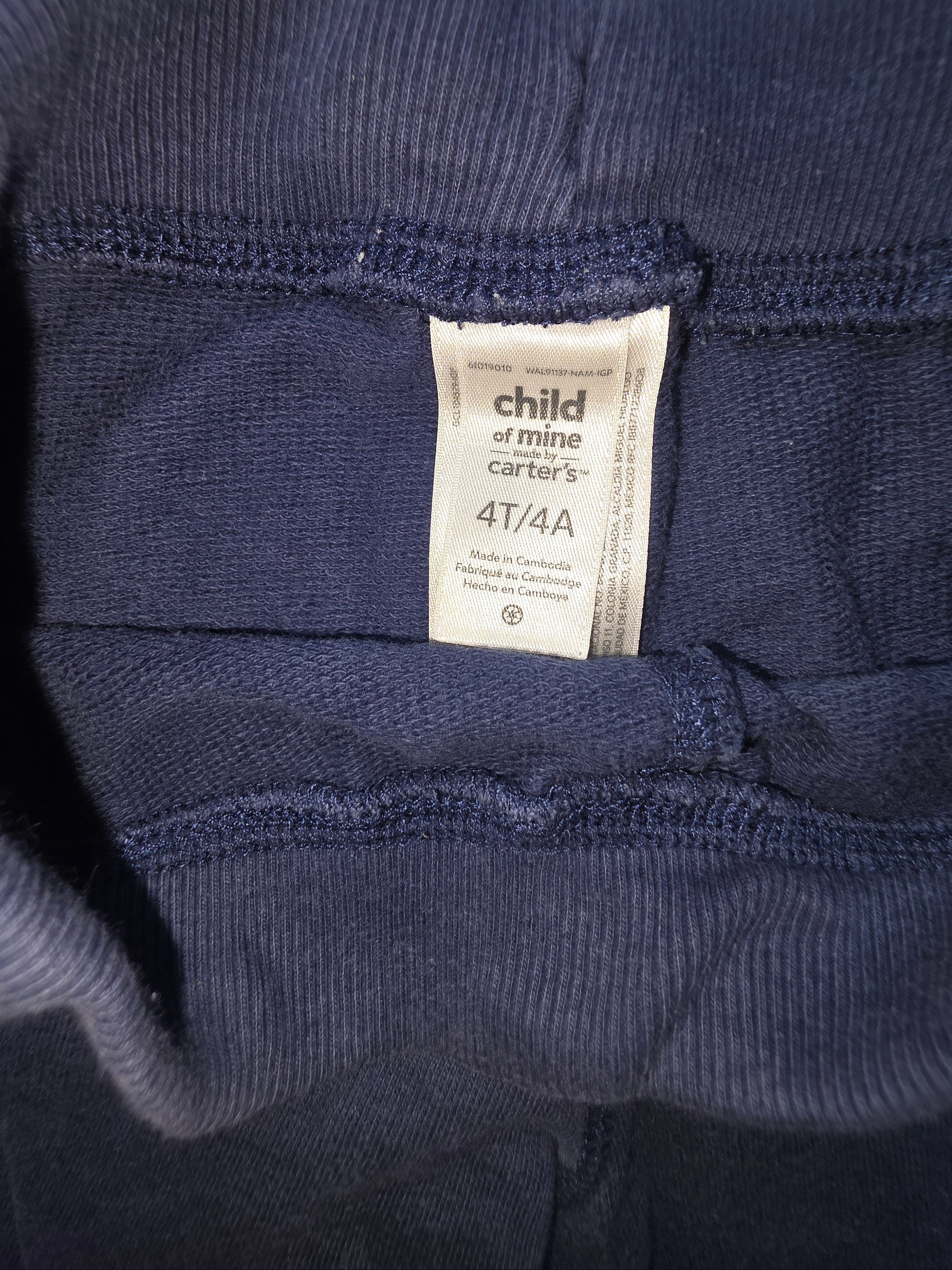 Navy blue sweater with a brand label on a neutral background