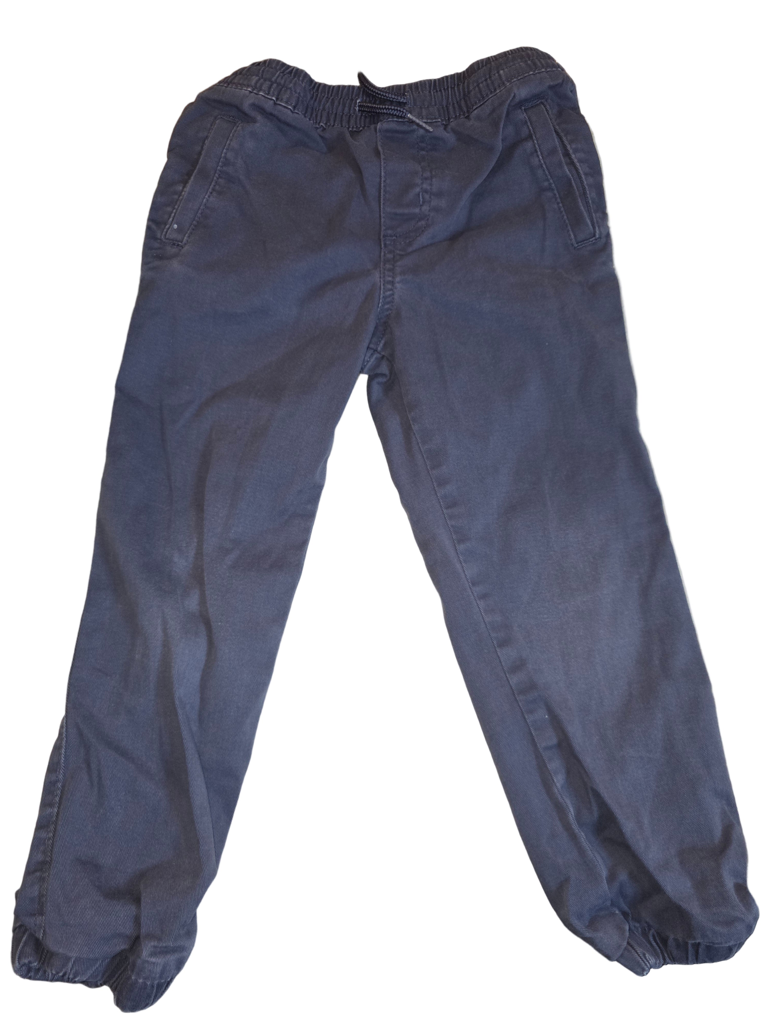 Folded blue pants on a beige surface