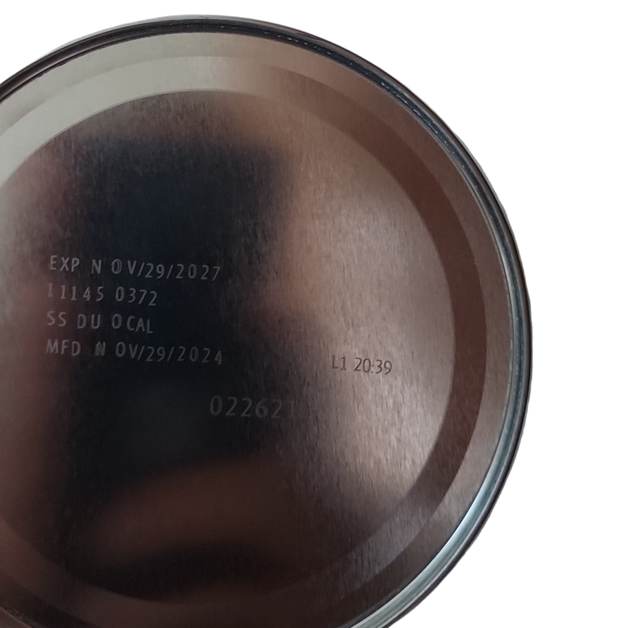 Close-up of a brown ceramic pot with visible text on a white surface