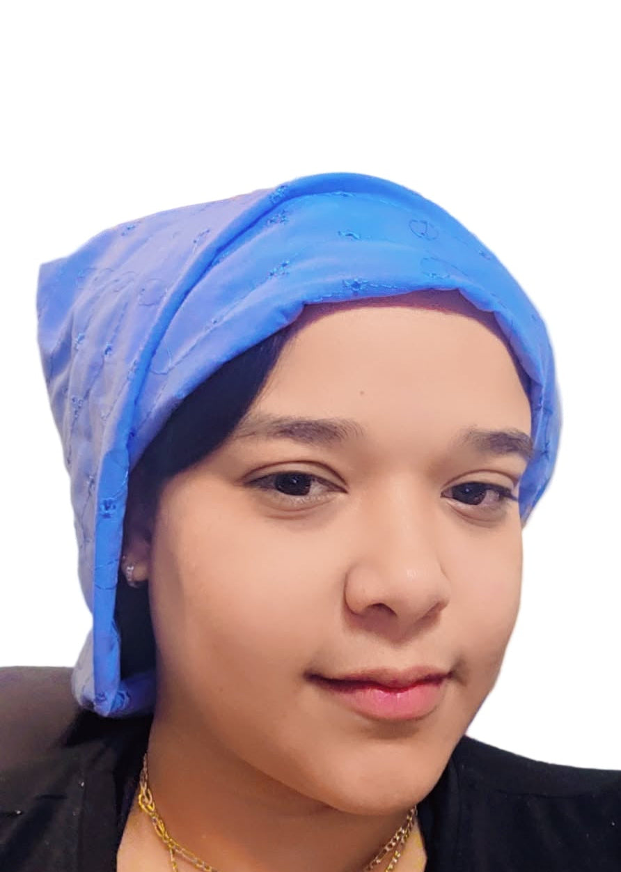 Person wearing a blue headscarf with a decorative painting in the background